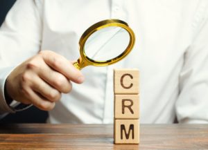 Wooden blocks with the word CRM (Customer Relationship Management) and businessman